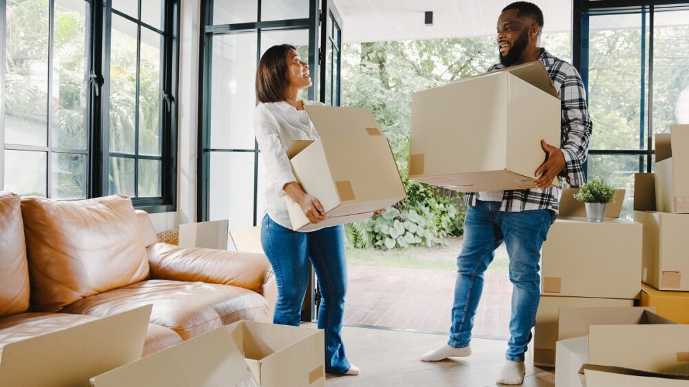 Feliz familia jovem comprou uma casa nova e está de mudança